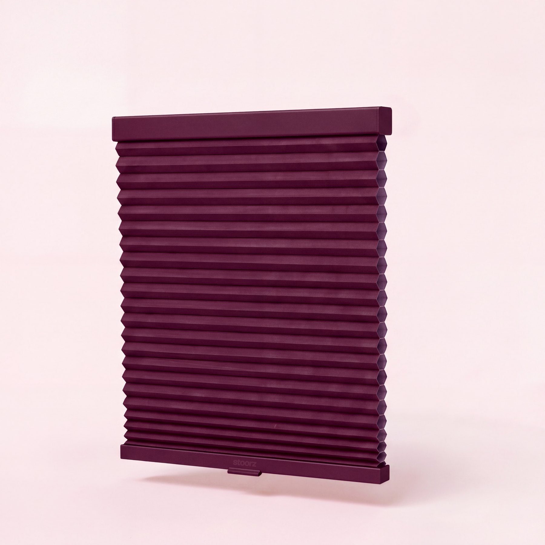 Store Stoorz avec son rail alu à bande adhésive, son tissu plissé et sa barre basse à poignée clipsable