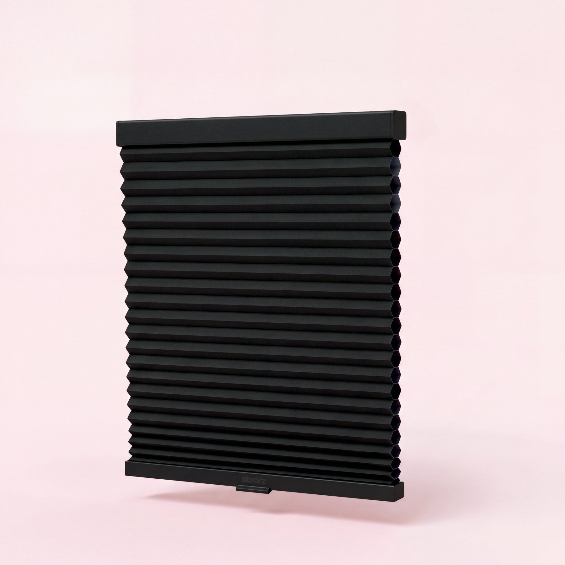Store Stoorz avec son rail alu à bande adhésive, son tissu plissé et sa barre basse à poignée clipsable
