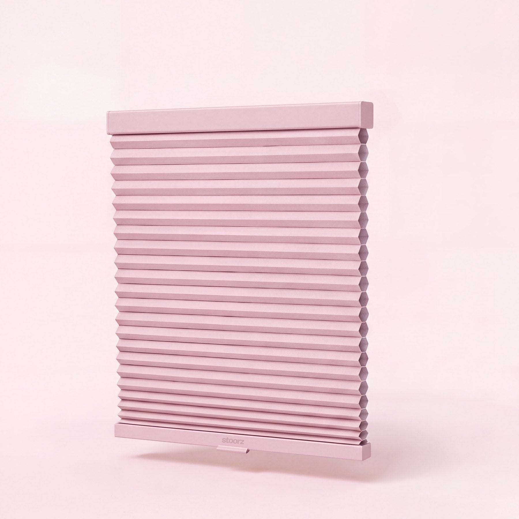 Store Stoorz avec son rail alu à bande adhésive, son tissu plissé et sa barre basse à poignée clipsable